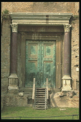 Вход в здание со старинными дверьми и колонами