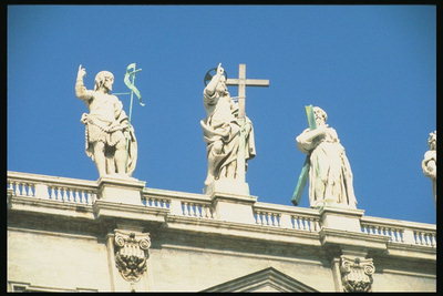 Скульптуры людей на крыше здания