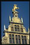 Статуя лошади золотого цвета на крыше дома