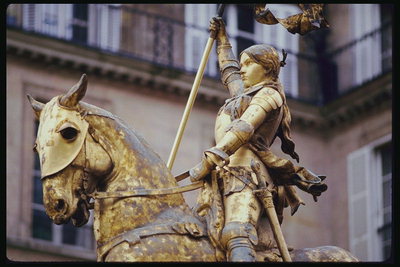 Жанна д\'Арк на лошади. Памятник в золотистых тонах