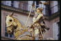 Жанна д\'Арк на лошади. Памятник в золотистых тонах