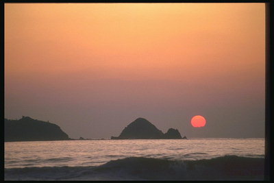 Закат солнца над морем. Скалы в море