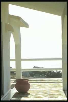 En pott på bordet. Från en balkong med utsikt över oändliga rymden