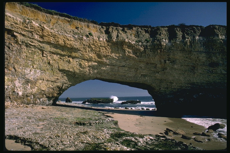 Скала на побережье с аркой