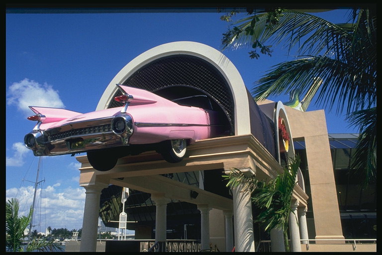 Hotel. Růžové auto na střeše hotelu vstup