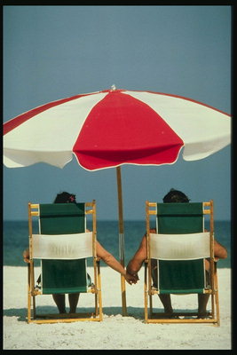 Флорида. Пляж. Отдыхающие под солнцезащитным зонтиком.