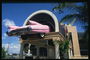 Гостиница. Розовая машина на крыше входа в гостиницу