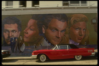 Den røde bil. En væg med billeder af mennesker