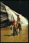 Dous nenos nun cabalo de pé nun lago de montaña