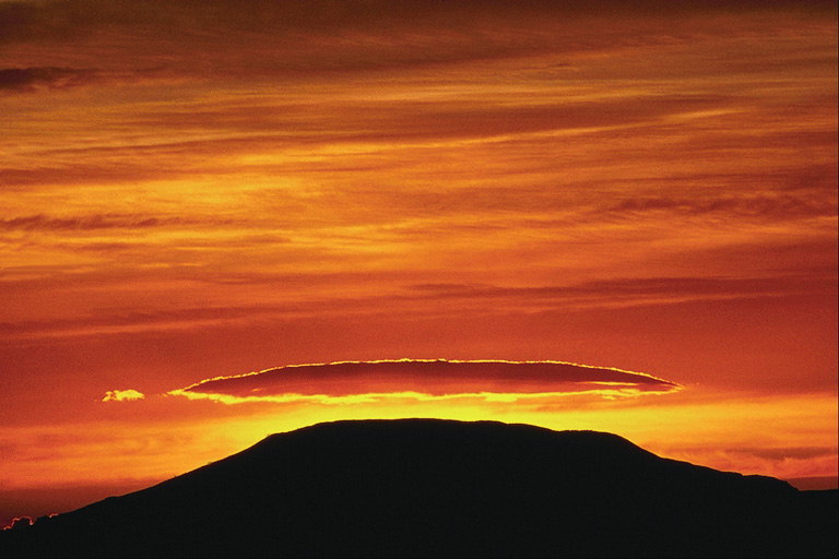 Ein orange Sonnenuntergang über dem Berg