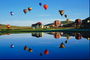 Множество воздушных шаров в небе над озером