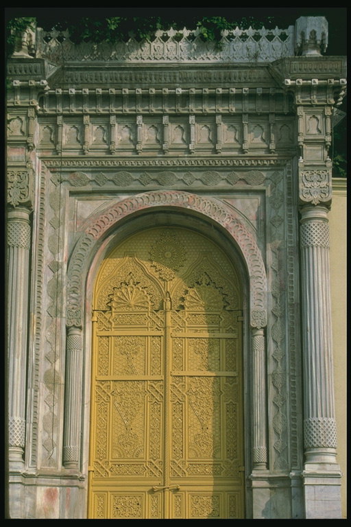 Вход в здание с резной дверью и колонами