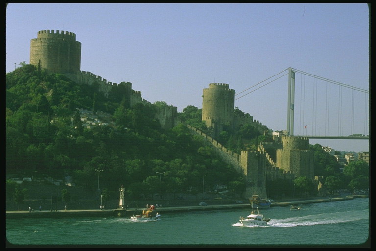 Холм с крепостями и башнями спускающимися в реку