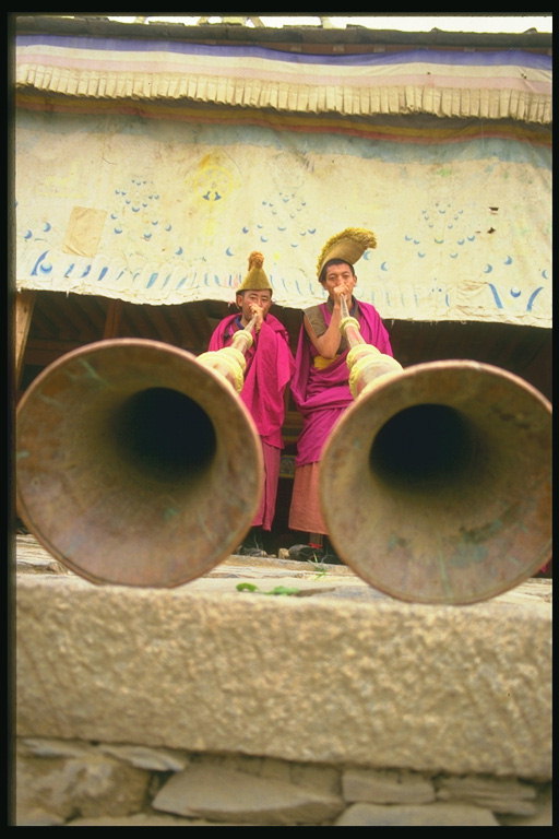 Два мужчины играют на огромных трубах