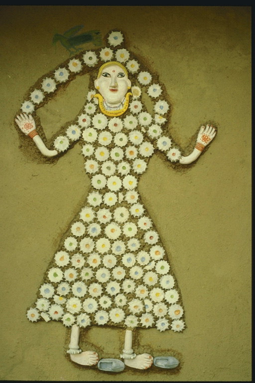 Изображение женщины на стене из глиняных цветов