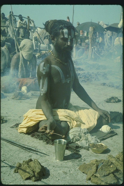 Мужчина сидящий в позе лотоса проводящий ритуал
