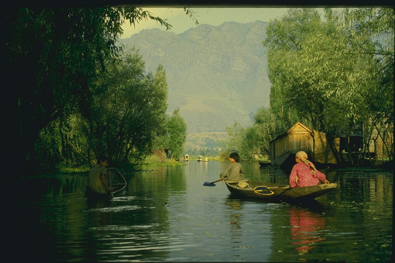 Плывущие дети на лодке через реку