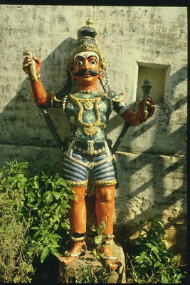 Скульптура мужчины с ритуальными предметами в руках