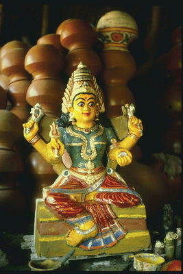 Скульптура женщины божества  с ритуальными предметами в руках