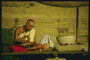 Монах сидящий на столе со скрещенными ногами с вазой в руке