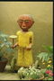 Статуя божества в жёлтой одежде с ритуальной посудой в руках