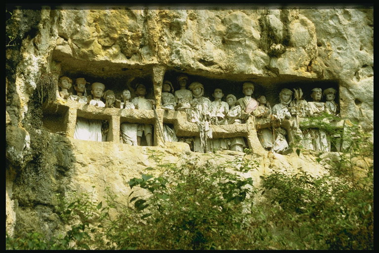 Скульптуры людей стоящих в проёме горы