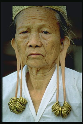Женщина с кольцами в ушах и отвисшими мочками ушей