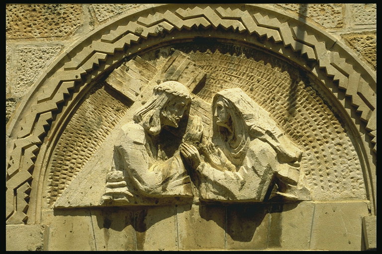 Скульптуры на стене храма. Иисус и женщина