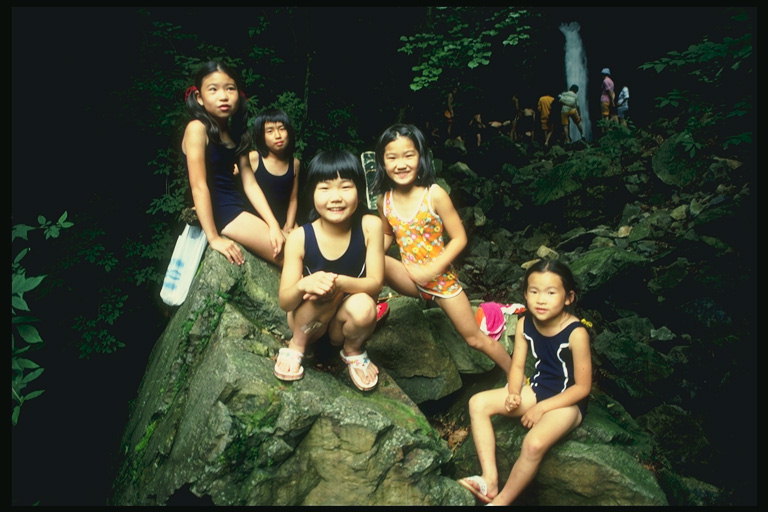Дети сидящие на большом камне