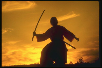 Японский воин с мечом в руках на фоне заката