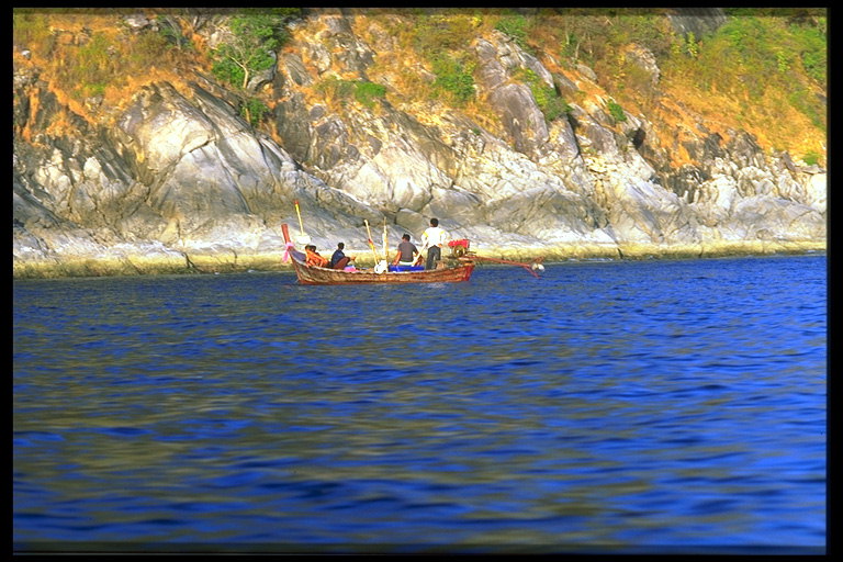 Рыбаки в лодке причаливают к берегу