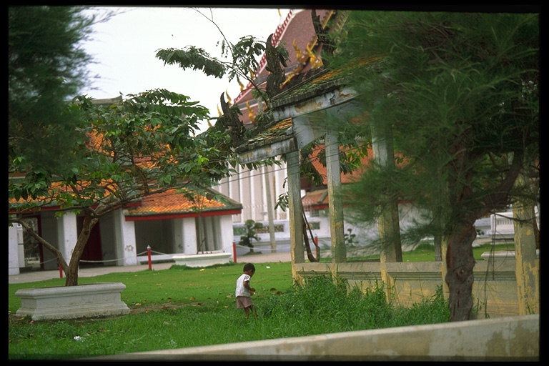 Играющий ребёнок на траве возле домов