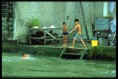 Купающиеся дети в реке возле домов