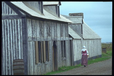 Женщина у стен деревянного дома