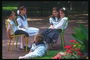 Дети сидят на стульях в парке и разговаривают