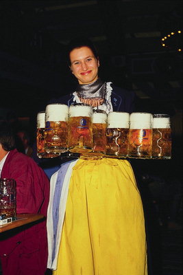 Женщина в фартуке с пивом в руках