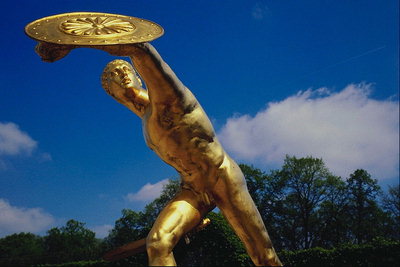 Статуя юноши с щитом в руках. Выполнена с метала золотистого цвета