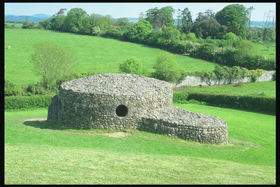 Каменная постройка среди зеленой лужайки
