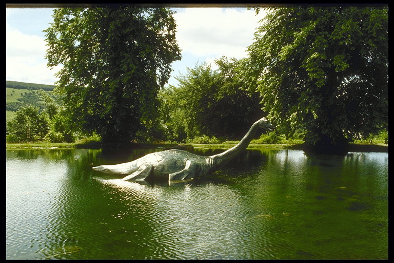Скульптура динозавра в озере