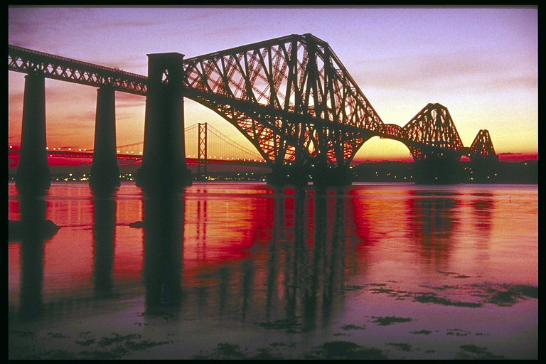 Мост через реку. Розовый закат над городом