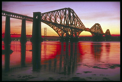 Мост через реку. Розовый закат над городом