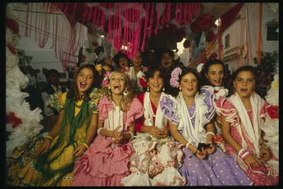 Молодые девочки в ярких платьях с цветами в волосах