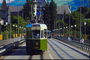 Зелёный трамвай движется по рельсам