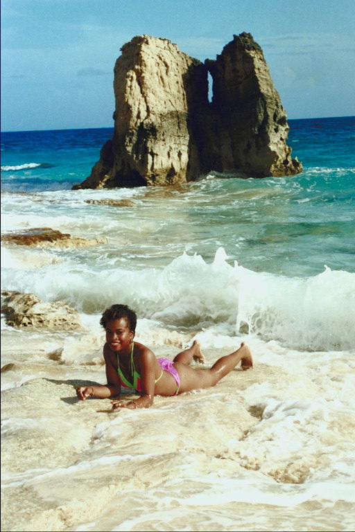 Девушка на белых песках пляжа. В морских волнах