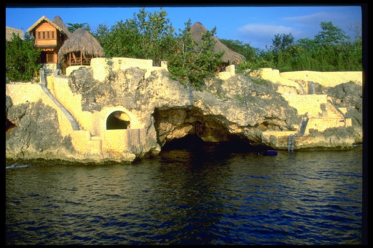 Домики на каменнистом берегу. Пещера