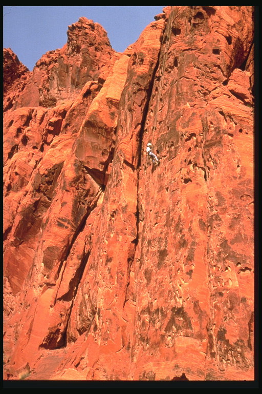 Альпинист спускающийся со скалы