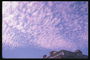 Воздушные сиреневого тона облака на голубом небе