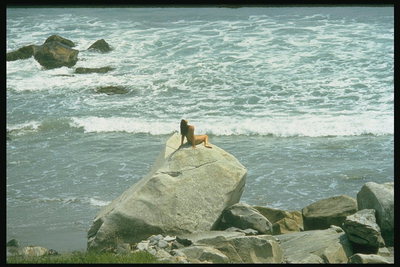 Девушка на камне у моря