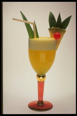 Pineapple cocktail in a glass with orange leg