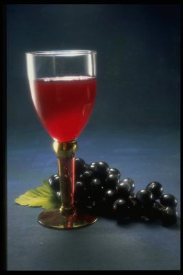 El vino tinto y un racimo de uvas